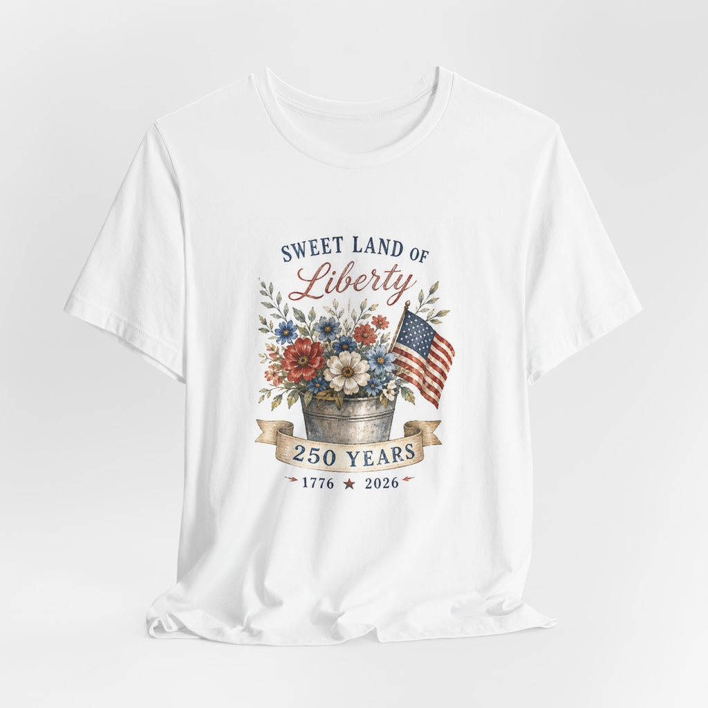 White t-shirt with "Sweet Land of Liberty" text, a floral arrangement, and American flag.