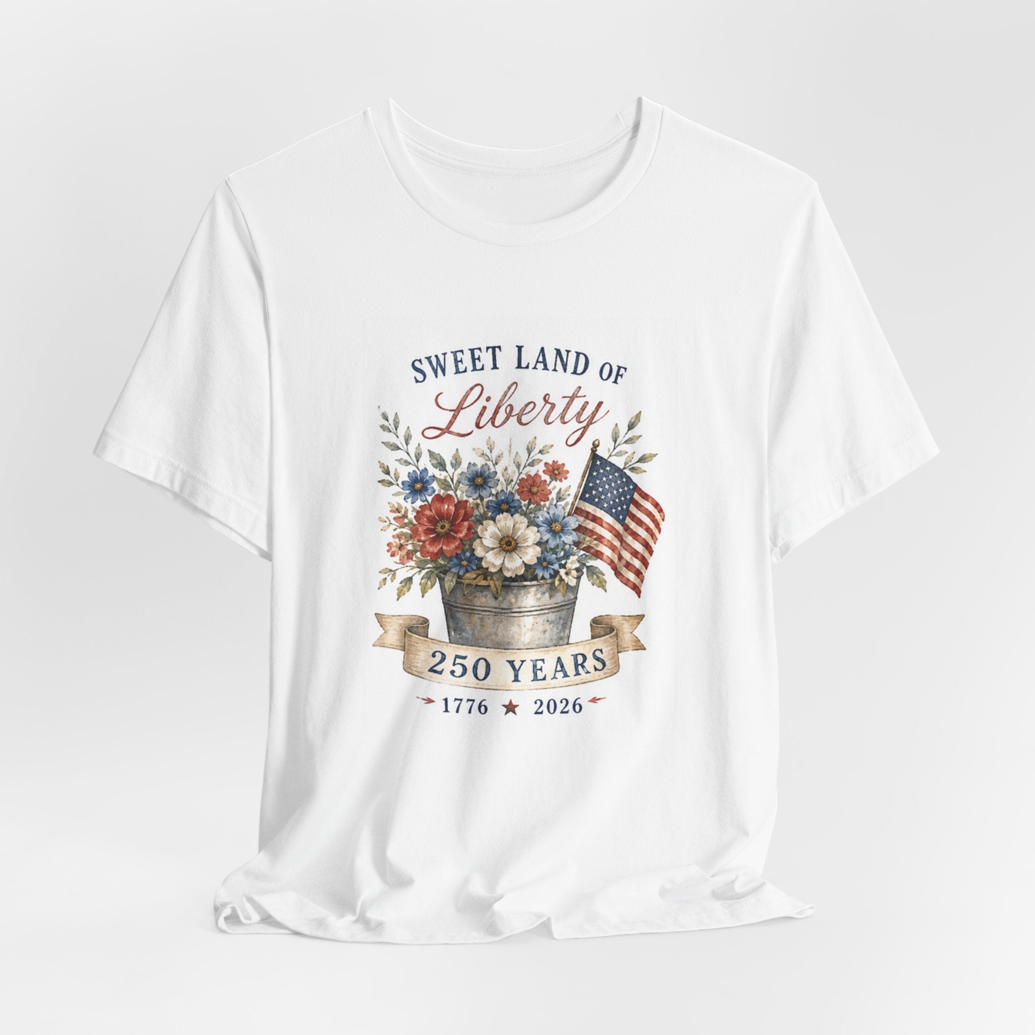 White t-shirt with "Sweet Land of Liberty" text, a floral arrangement, and American flag.