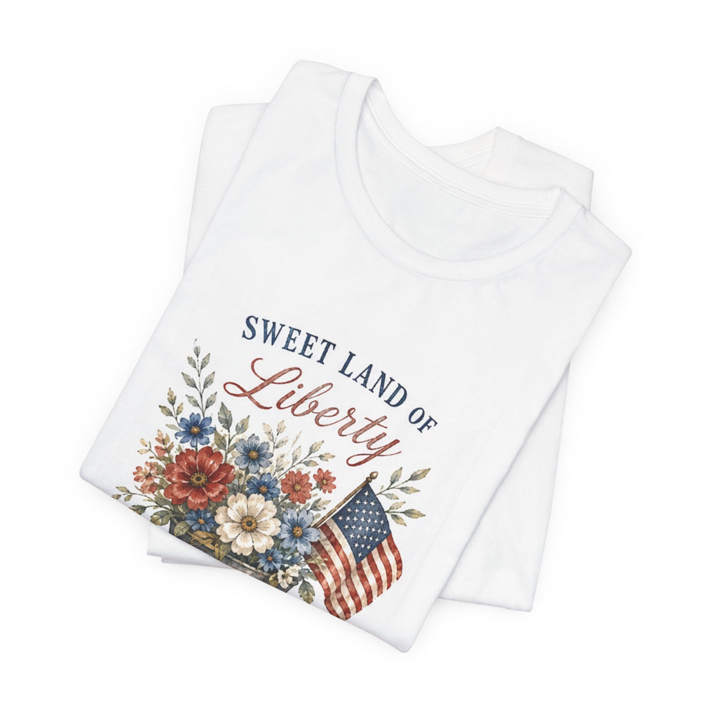White t-shirt with "Sweet Land of Liberty" text and patriotic floral design.